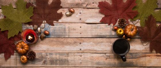 Fall foliage on wooden table with a mug sitting on top