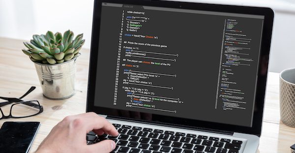 Developer programming on a laptop at a desk