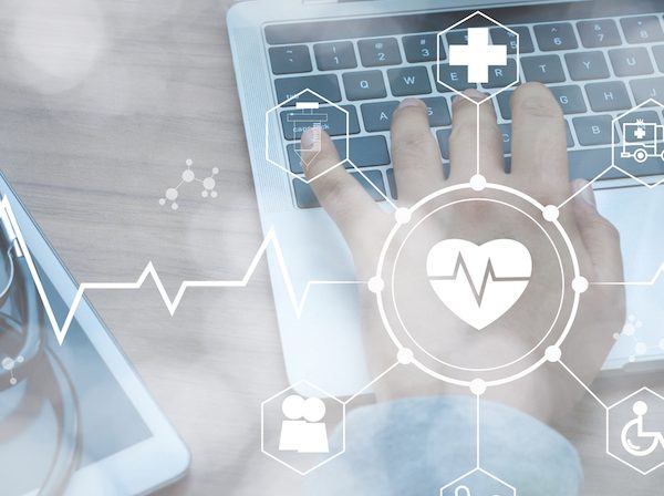 Stethoscope lies on tablet and white icon medical with hand doctor using laptop to securely exchange healthcare data. Healthcare business technology network concept.